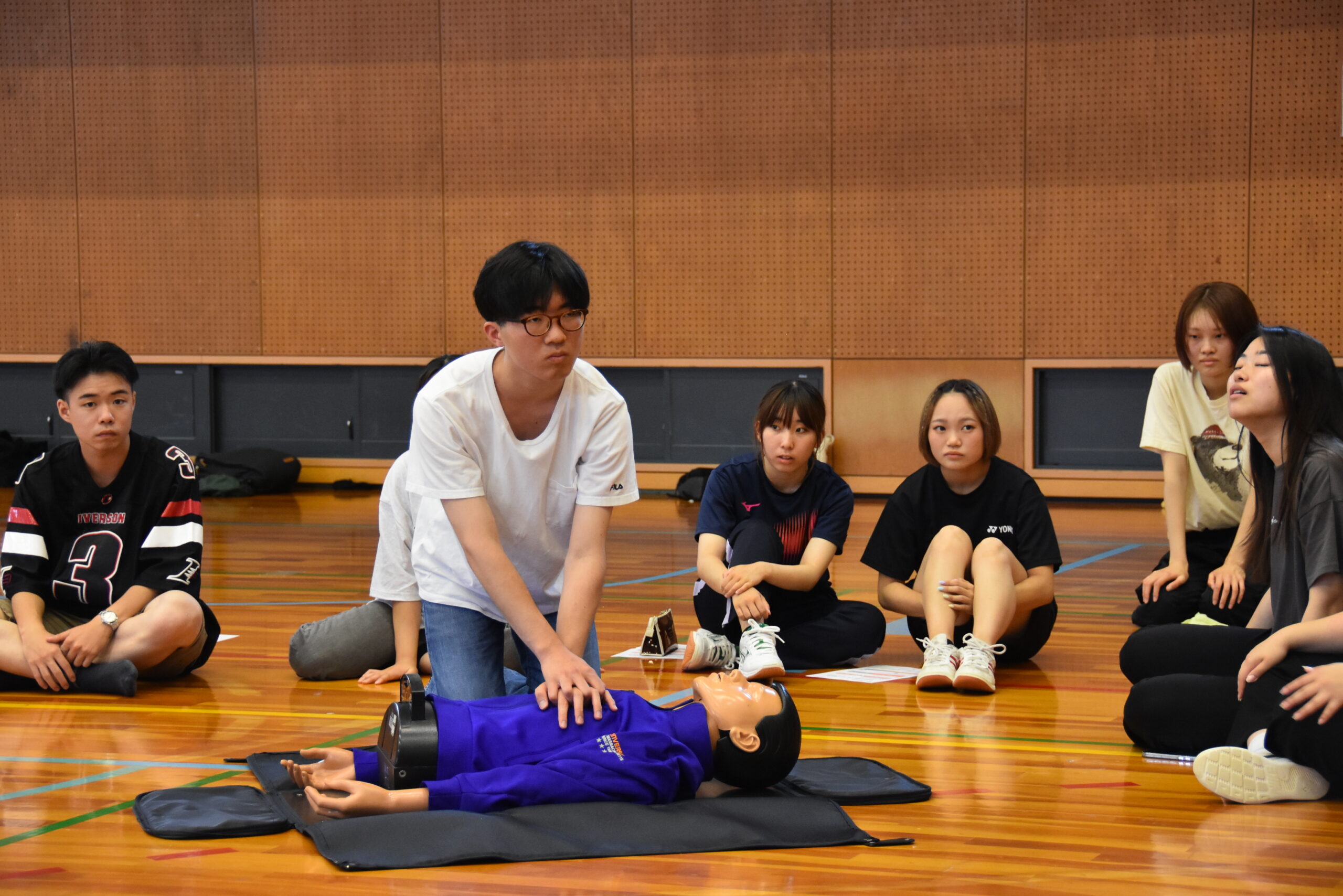 関西外大中宮キャンパス体育館で救命講習会が開かれ、約100人の学生が心肺蘇生法やAEDの使い方を学びました
